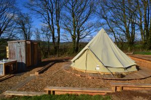 Our Bell Tent with its own deck and facilities (kitchen, shower and toilet). It comes with a double bed and two singles.Please bring your own bed linen and utensils.